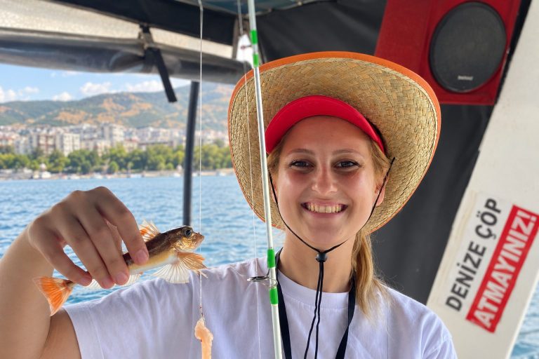 Teknede tuttuğu balığı gösteren katılımcı